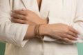 Farah El Khoury Jewelry, image of two hands showcasing golden ring and bracelet