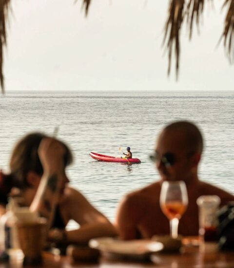 Pierre and Friends, image of a couple sitting on the bar with the Seaview behind them and small kayak