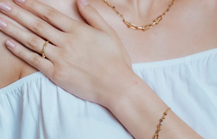 Farah El Khoury Jewelry, image of a woman showcasing golden bracelet and golden necklace
